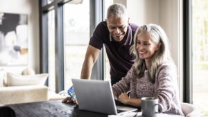 Senior couple using laptop at home