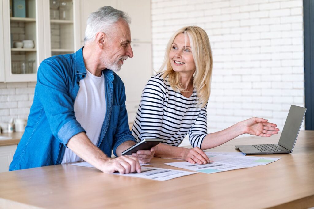 Mature wife and husband checking documents with tax, pension savings