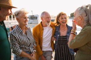 Group of happy senior friends tourists standing in city, talking.