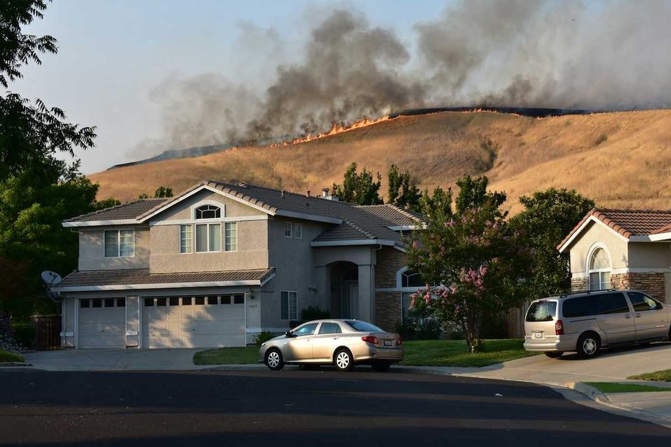 wildfire-on-ridgetop-threatens-a-neighborhood-suburban-home-with-vehicles-in-driveway