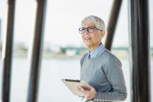 Portrait of confident senior woman with digital tablet outdoors