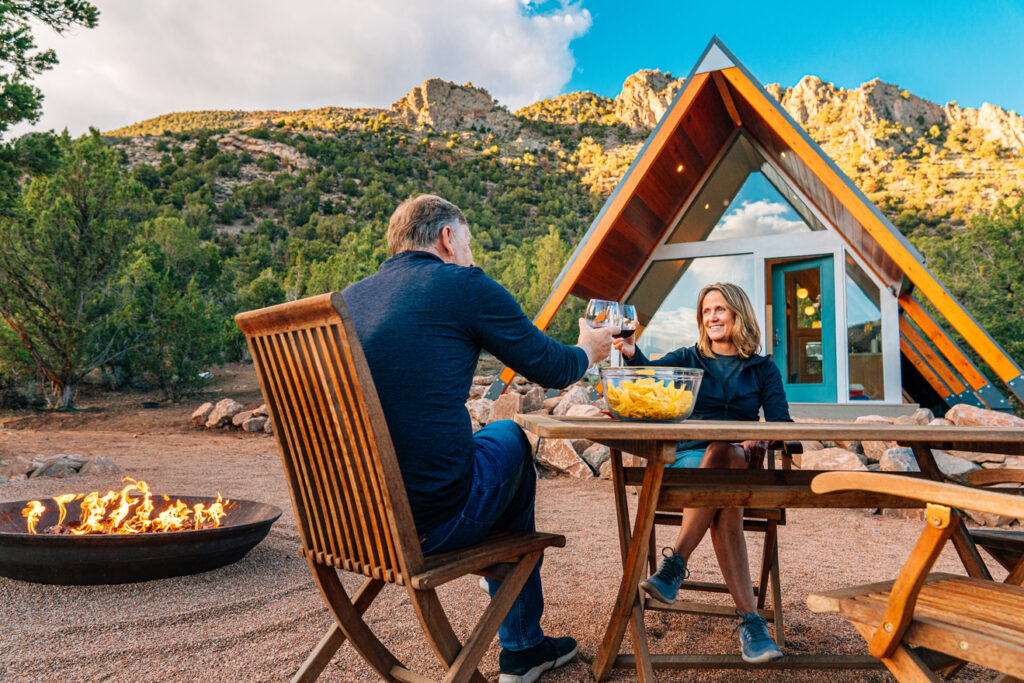 couple-toasting-over-table-outside-house
