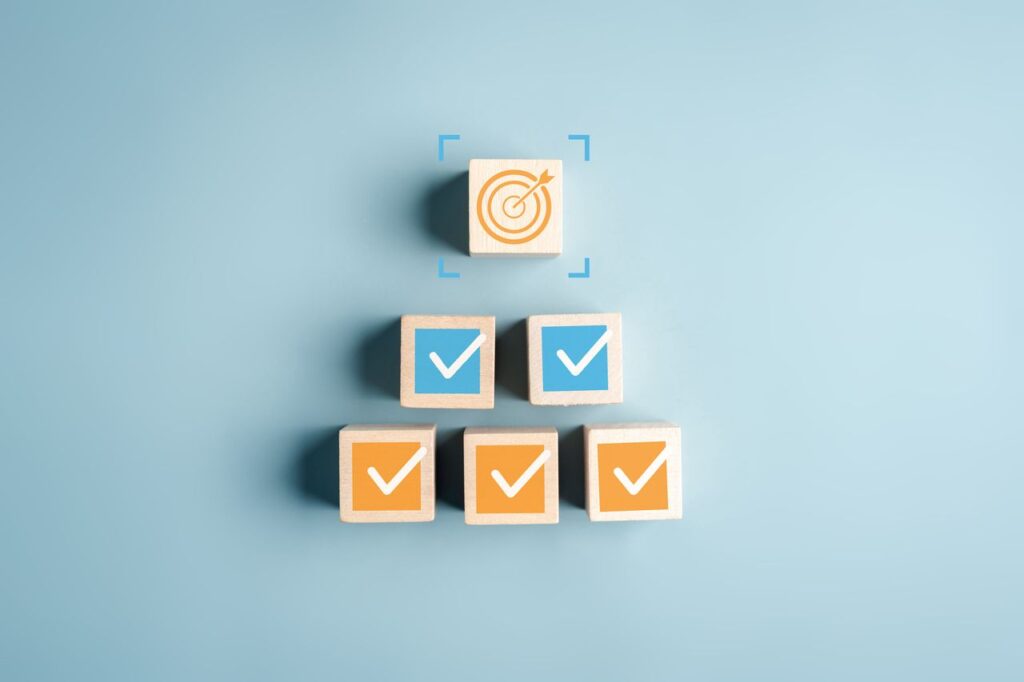 Checklist target process planning strategy checkmarks and goal on wooden blocks project steps, achievement, and business performance.